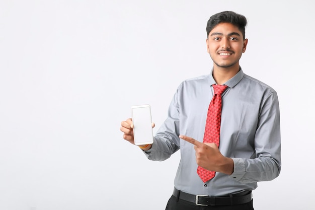 Concepto de tecnología: joven empresario indio que muestra la pantalla del teléfono inteligente.