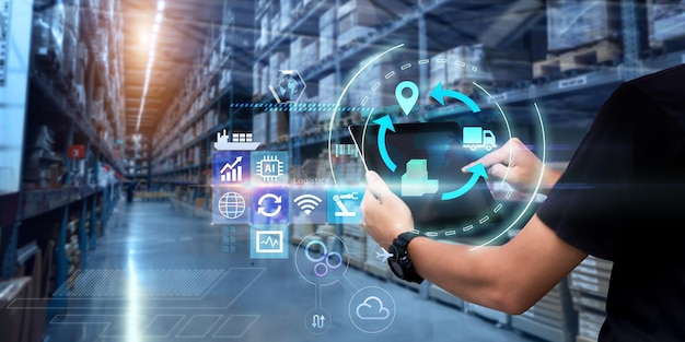 Concepto de tecnología de logística empresarial Manos de hombre usando tableta en almacén borroso como fondo