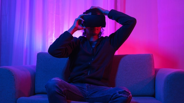 Concepto de tecnología de metaverso Hombre que sostiene gafas de realidad virtual y diviértete envolvente futurista en metaverso