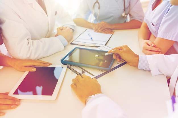 concepto de tecnología, personas y medicina - grupo de médicos con tabletas y portapapeles reunidos en el hospital