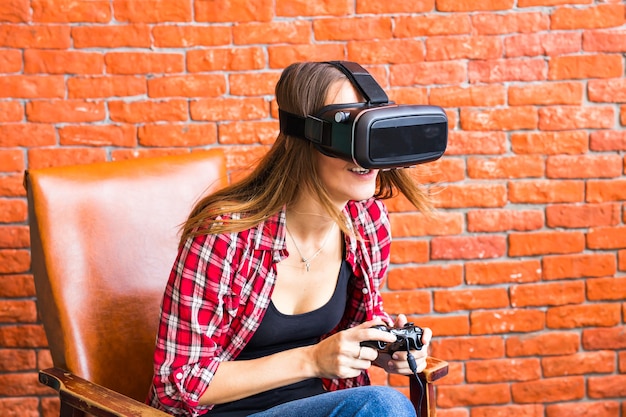 Concepto de tecnología, realidad virtual, entretenimiento y personas 3d - mujer joven feliz con casco de realidad virtual o gafas 3d jugando y luchando