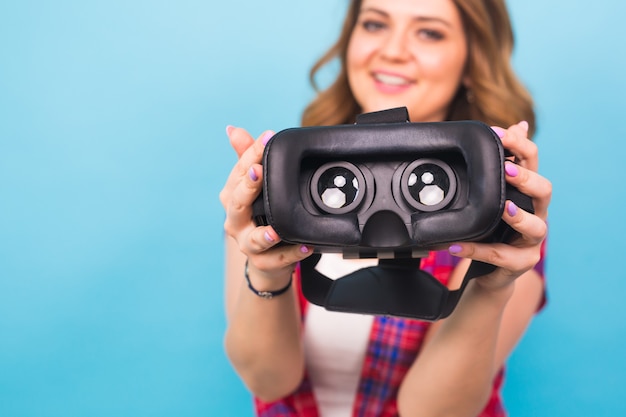 Concepto de tecnología, realidad virtual, entretenimiento y personas: la chica da gafas de realidad virtual.