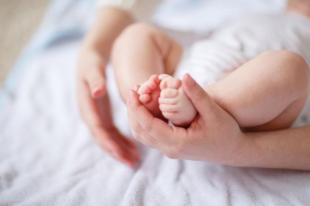 Concepto de tierna madre sosteniendo el pie del bebé recién nacido