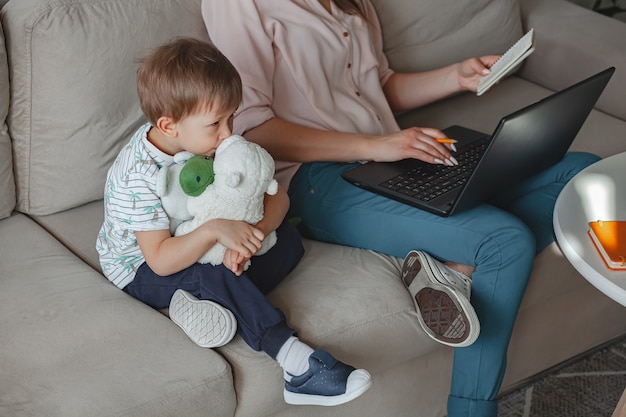 Concepto de trabajo en casa y educación familiar en casa, madre trabajando con portátil