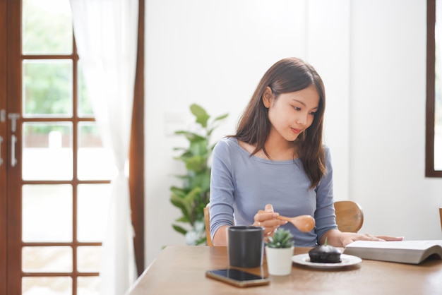 Concepto de trabajo desde casa Las mujeres de negocios están leyendo un libro y comiendo postre para relajarse en la sala de estar