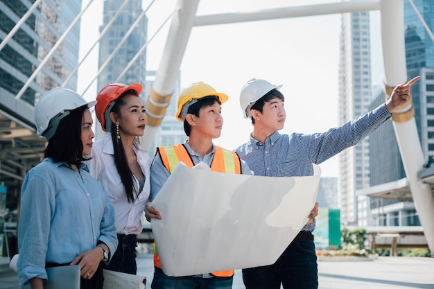 Concepto de trabajo en equipo. Los ingenieros están discutiendo con un colega, están planeando construir.