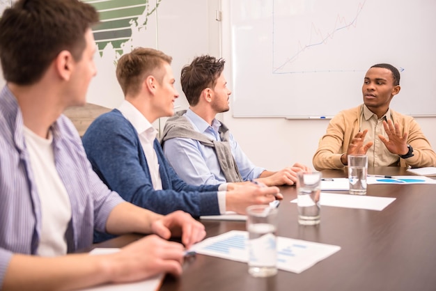 Concepto de trabajo en equipo Jóvenes socios comerciales compartiendo y discutiendo ideas en una reunión en la oficina