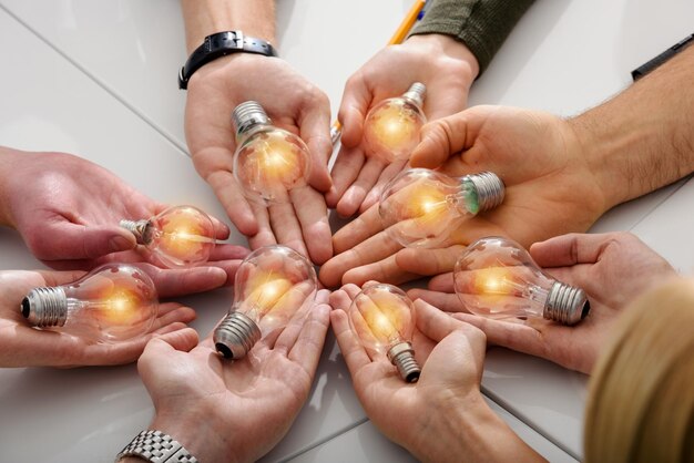 Concepto de trabajo en equipo y lluvia de ideas con empresarios que comparten una idea con una lámpara
