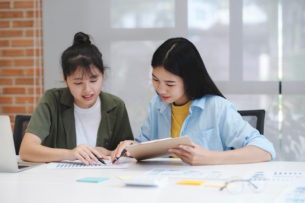 Concepto de trabajo en equipo de negocios asiáticos de inicio discutiendo gráficos que muestran los resultados