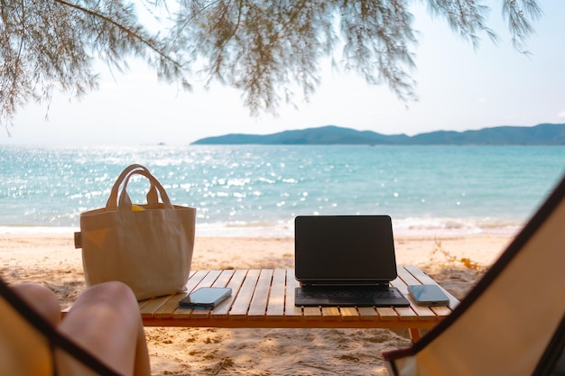 Concepto de trabajo independiente en línea y picnic al aire libre en la playa con tableta