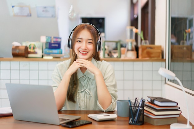 Concepto de trabajo remoto Mujer empresaria usa auriculares para escuchar música en el espacio de coworking