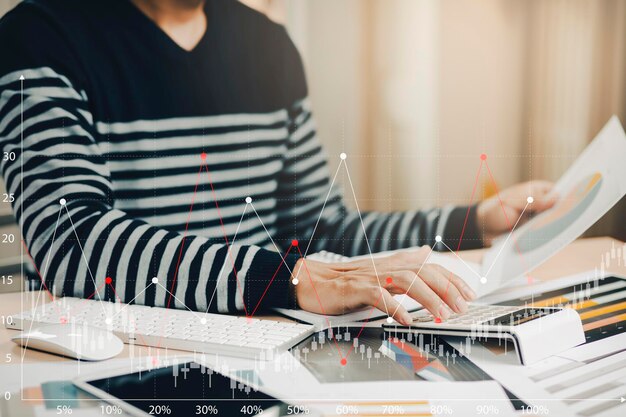 Concepto de transacciones financieras en línea, el papel gráfico comercial de Business sostiene el punto de análisis financiero de los datos mientras se discute, planifica el presupuesto de promoción de la marca, aumenta la conciencia de la empresa en los medios sociales