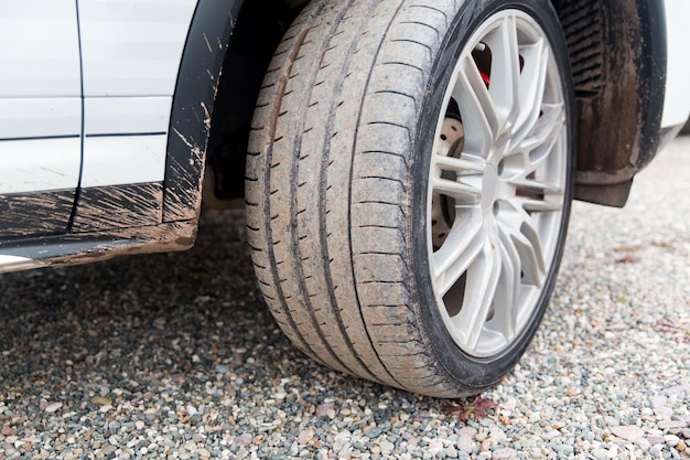 concepto de transporte, conducción y vehículos de motor - cierre de la rueda de coche sucia en el suelo