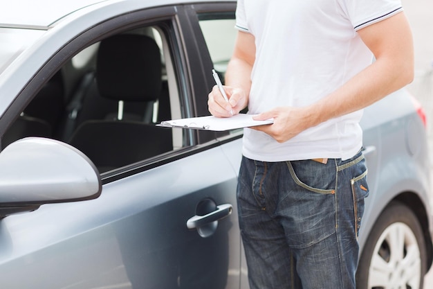 concepto de transporte y propiedad - hombre con documentos de coche