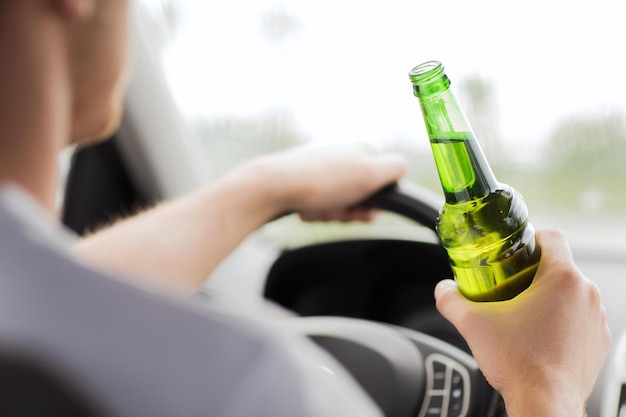 Concepto de transporte y vehículo: hombre bebiendo alcohol mientras conduce el automóvil