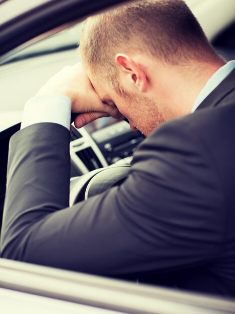 Foto concepto de transporte y vehículo - hombre de negocios cansado o taxista