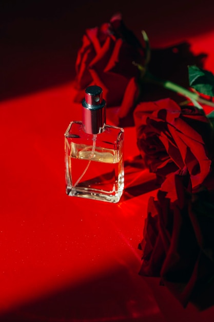 concepto de tratamiento de belleza de rosas rojas y botellas de perfume