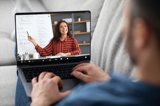 Concepto de tutoría en línea Hombre que tiene una lección virtual con tutora de inglés femenino