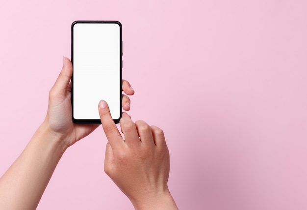 Concepto de uso del teléfono inteligente. Un teléfono inteligente con una pantalla en blanco en blanco en manos de una mujer.