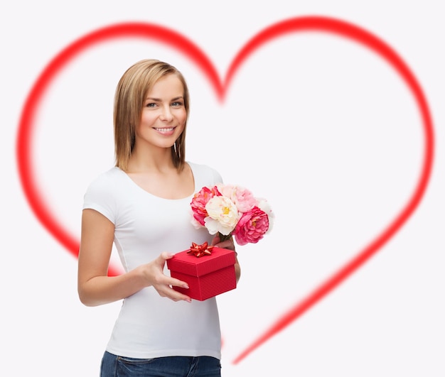 Concepto de vacaciones, amor y flores - mujer joven con ramo de flores y caja de regalo roja
