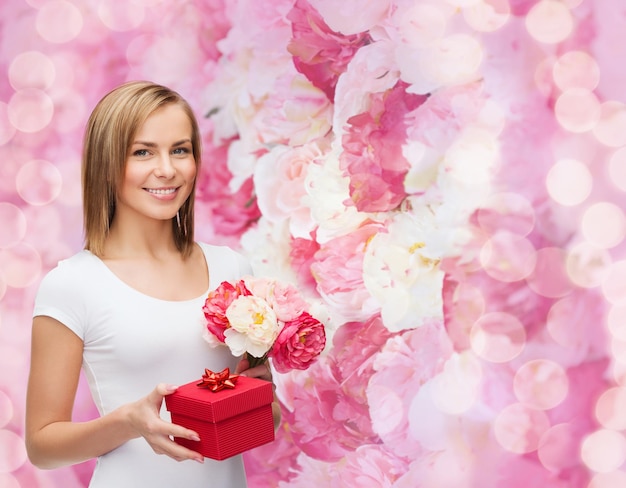 concepto de vacaciones, amor y flores - mujer joven con ramo de flores y caja de regalo roja