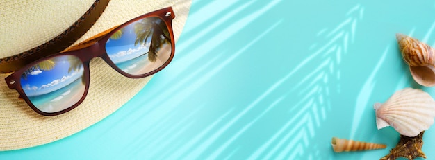 concepto de vacaciones y banner de viajes de verano Felices vacaciones en la playa de arena tropical Sombrero de Panamá y gafas de sol con un reflejo de la playa de arena trovic y palmeras Copiar espacio