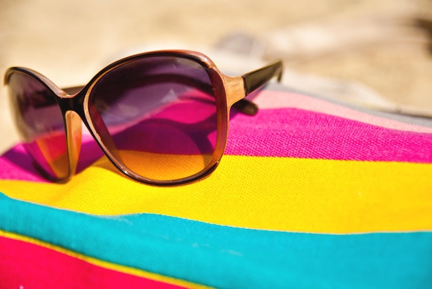 Foto concepto de vacaciones con bolsa y gafas en la arena.