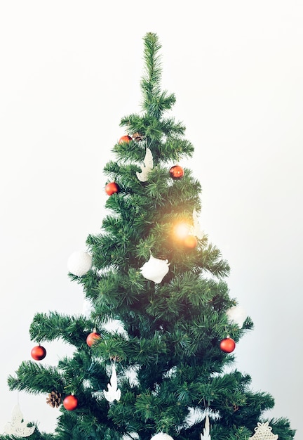 Concepto de vacaciones y celebración - árbol de Navidad decorado sobre fondo blanco.