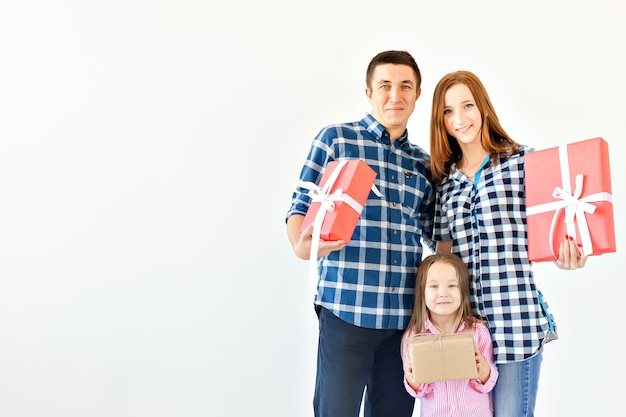 Concepto de vacaciones y celebración - Familia feliz con regalos de Navidad sobre fondo blanco con espacio de copia