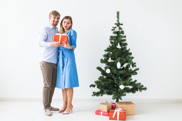 Concepto de vacaciones y celebración - Hombre dando un regalo de Navidad a su novia.