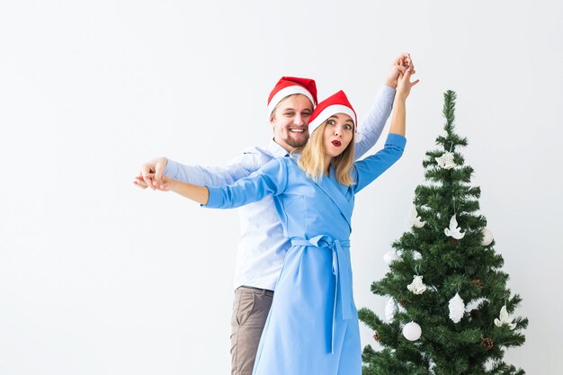 Concepto de vacaciones y celebración - Pareja joven celebrando la Navidad en casa.