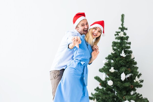 Concepto de vacaciones y celebración - Pareja joven celebrando la Navidad en casa.