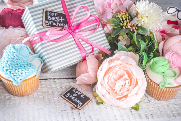 Concepto de vacaciones del día de los abuelos, fondo de saludo del día de la abuela y el abuelo. Magdalenas caseras dulces para la abuela y el abuelo, con la inscripción de texto Te amo Granny. Con regalos y flores