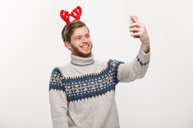 Concepto de vacaciones y estilo de vida Joven apuesto hombre con barba tomándose un selfie o hablando cara a cara con un amigo