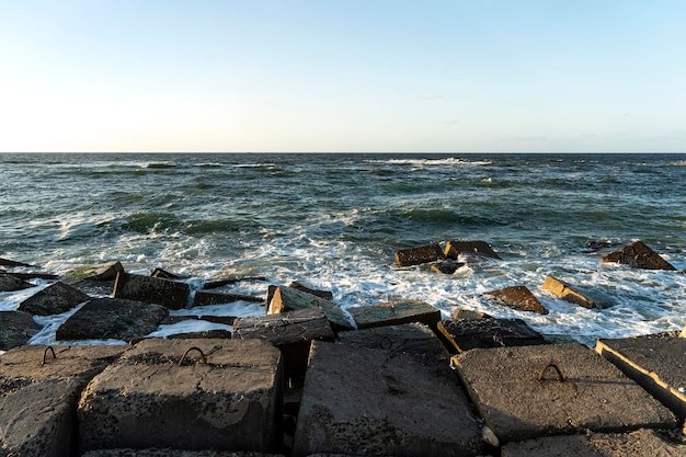 Concepto de vacaciones Fondo del mar Hermoso paisaje de verano Piedras del mar y surfear las rocas de las olas Superficie del agua del mar iluminada por la luz del sol Escena de agua de mar soleada de verano