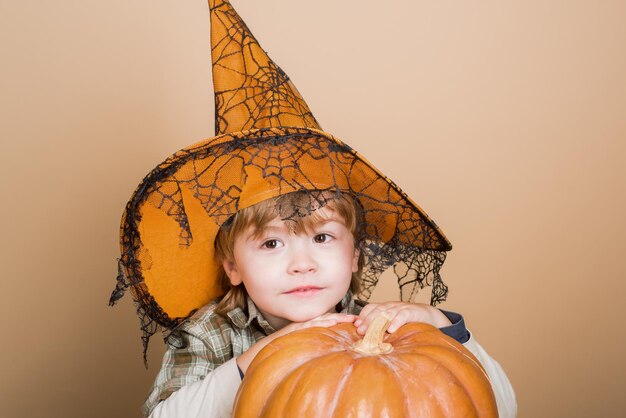 Concepto de vacaciones de Halloween feliz halloween niño divertido niño con sombrero de bruja para halloween con calabaza
