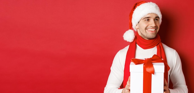 Concepto de vacaciones de invierno navidad y estilo de vida primer plano de hombre atractivo en sombrero de santa y bufanda ...