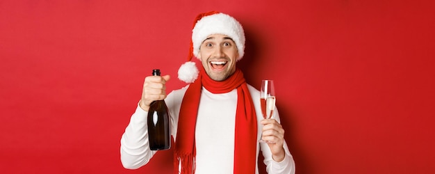 Concepto de vacaciones de invierno navidad estilo de vida primer plano de hombre guapo alegre sosteniendo champán...