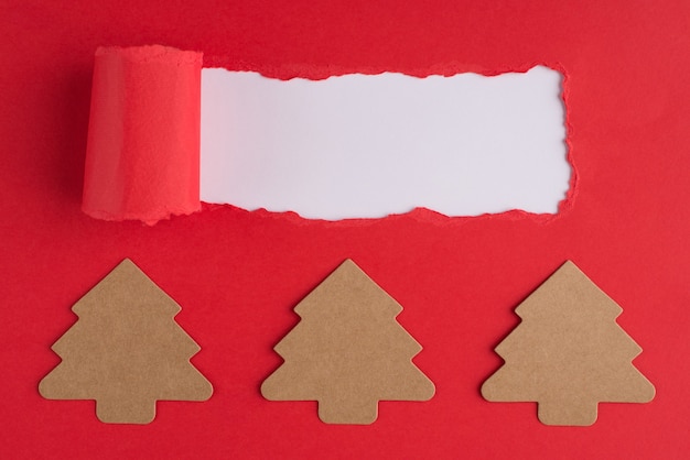 Concepto de vacaciones de Navidad. Arriba arriba foto de vista aérea de papel con forma de árbol de navidad y papel rojo rasgado sobre fondo blanco con copyspace
