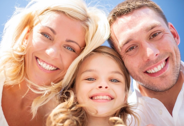 concepto de vacaciones, niños y personas de verano - familia feliz con cielo azul