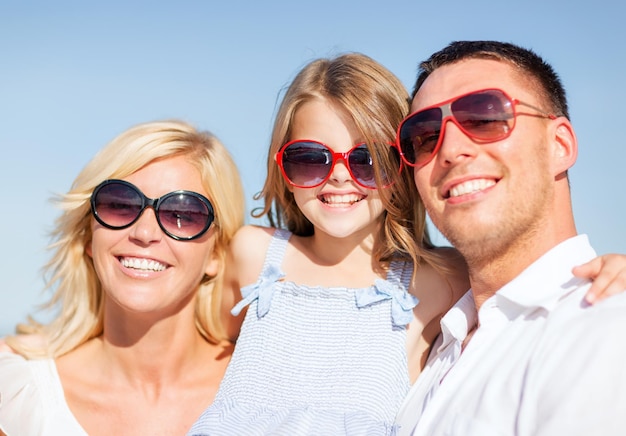 concepto de vacaciones, niños y personas de verano - familia feliz con cielo azul