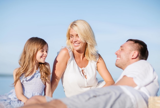 concepto de vacaciones, niños y personas de verano - familia feliz haciendo un picnic