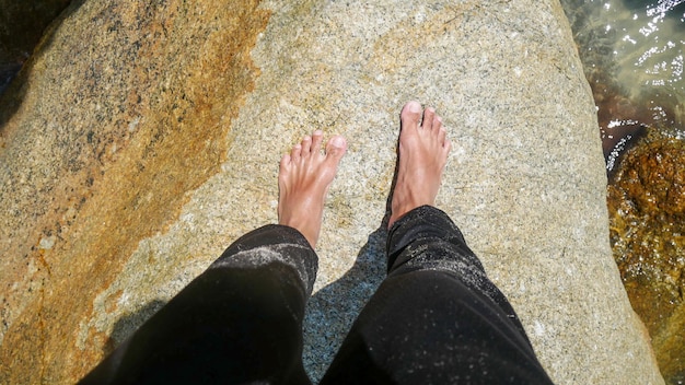 Concepto de vacaciones Primer plano de piernas masculinas caminando por la playa