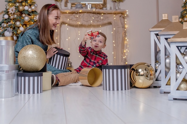 Concepto de vacaciones y regalos - Primer plano de la familia abriendo regalos en Navidad