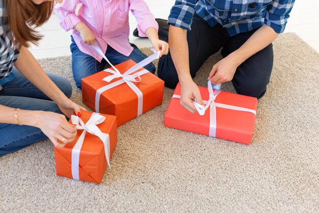 Concepto de vacaciones y regalos - Retrato de una familia feliz abriendo regalos en Navidad.