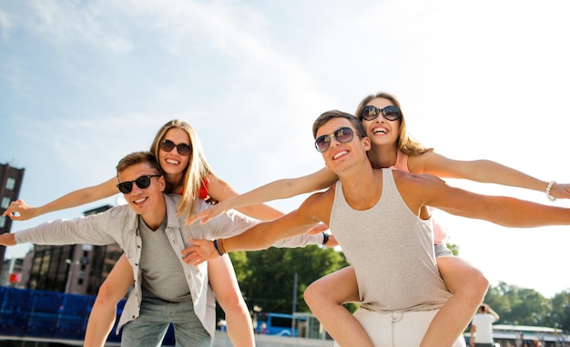 concepto de vacaciones, vacaciones, amor y amistad - pareja sonriente divirtiéndose en la ciudad