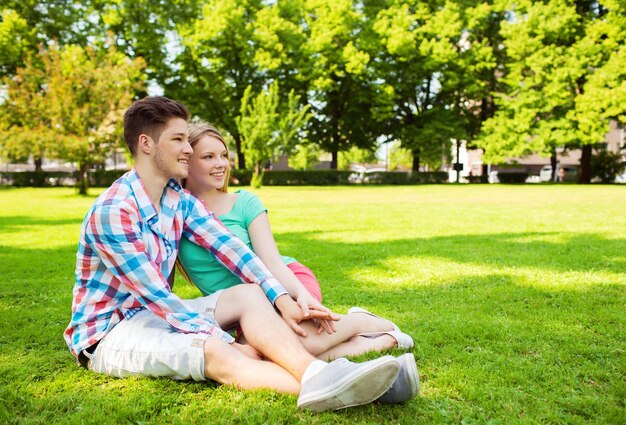 concepto de vacaciones, vacaciones, amor y amistad - pareja sonriente en el parque