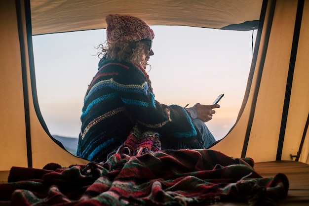 Concepto de vacaciones de vacaciones de invierno con mujer adulta de color alternativa gratuita haciendo camping con carpa en actividad de ocio al aire libre