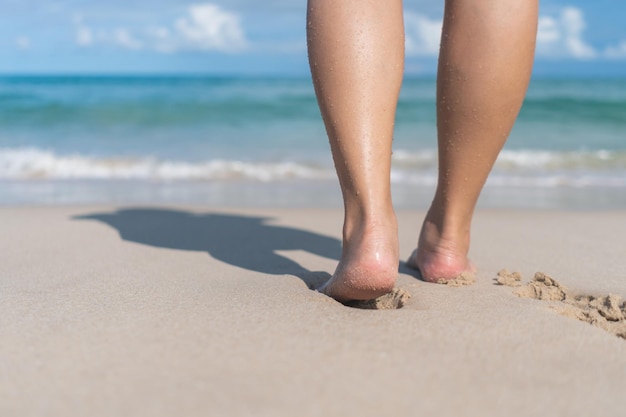 Concepto de vacaciones de verano descalzo sobre la arena en la playa con copyspace