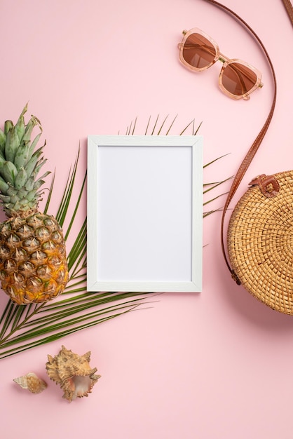 Concepto de vacaciones de verano Foto vertical de vista superior de marco blanco piña redonda bolsa de ratán gafas de sol conchas y hojas de palma sobre fondo rosa pastel aislado con espacio en blanco